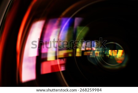 Macro shot of front element of a camera lens with beautiful color lights reflections