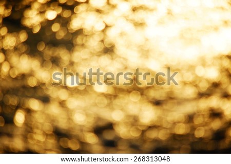 Gold festive abstract background with bokeh de-focused lights and stars.