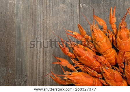 Two red crayfishes wrestling on old dark wooden table