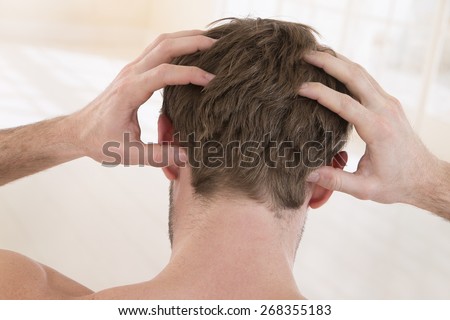 back view of  a young man suffering from itchy scalp