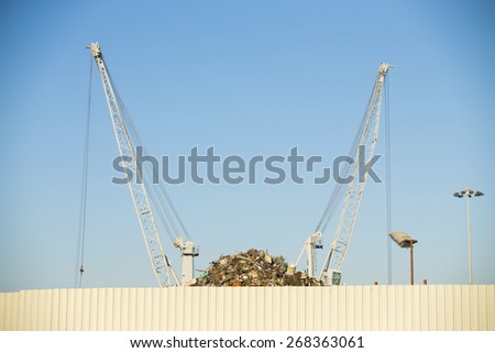 Crane claw on top of pile with scrap metal in recycling center