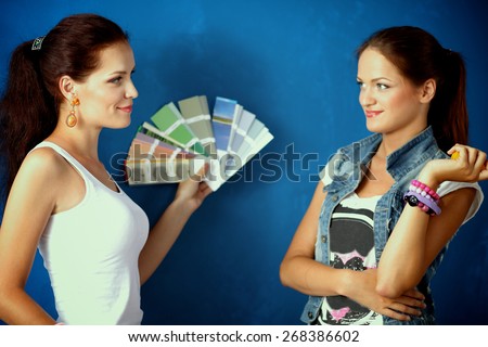 Two Young beautiful weman holding color palette with color samples.