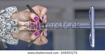 Lady signs formal paper. Woman hands working on paper document on glass office table making string reflection with fountain pen stylish nail make-up soft smothered background cool tones pen cap