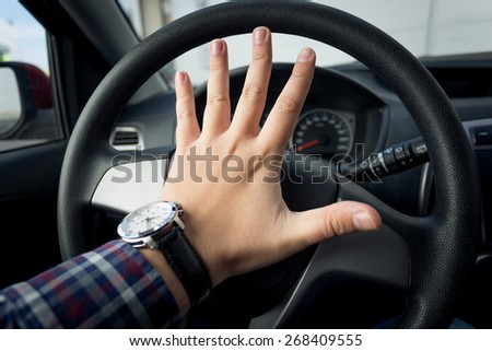 Closeup photo of angry driver honking in traffic Royalty-Free Stock Photo #268409555