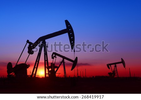 Several are operation of pumping unit under the setting sun, close-up 