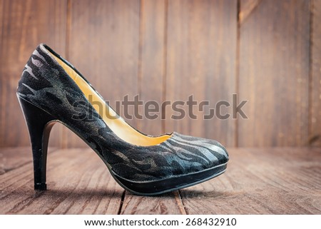 Black high heel on wooden background - vintage effect style pictures
