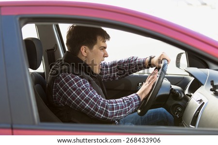 Closeup portrait of aggressive male driver honking in traffic jam Royalty-Free Stock Photo #268433906