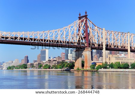 Queensborough Bridge in Midtown Manhattan with New York City skyline over East River as the famous landmarks viewed from Brooklyn.