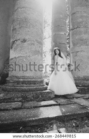 Young bride  posing  against an old church. Wedding picture in black and white. 