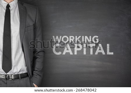 Working capital on black blackboard with businessman