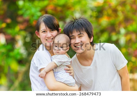 a happy family smiling together in the garden.Portrait of Asian family.