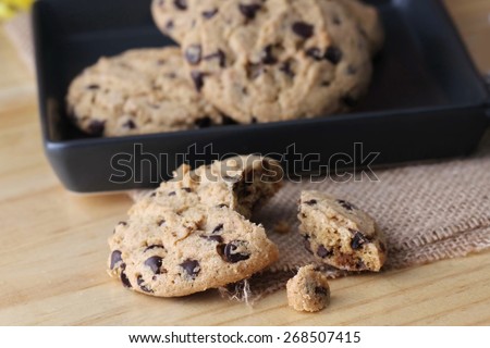 Chocolate chip cookies on linen napkin on wooden table. Stacked cookies 