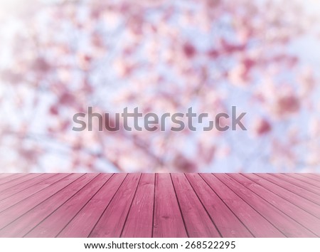 Empty perspective red wood over blurred, blooming trees with bokeh background, for product display montage