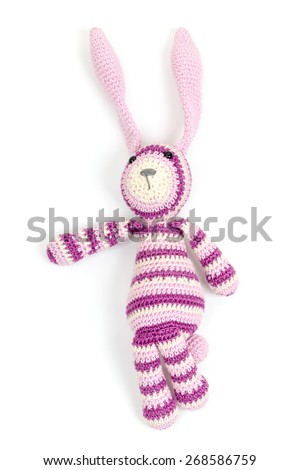 Funny pink knitted rabbit toy showing left direction isolated on white background with soft shadow