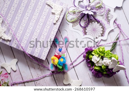 Picture of artistic handmade rabbit, gift box and decorations on wooden table background
