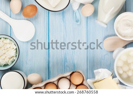 Dairy products on wooden table. Sour cream, milk, cheese, egg, yogurt and butter. Top view with copy space Royalty-Free Stock Photo #268760558