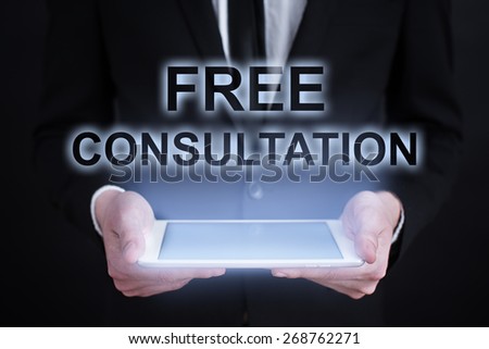 Businessman holding a tablet pc with free consultation text on virtual screen. Internet concept. Business concept.