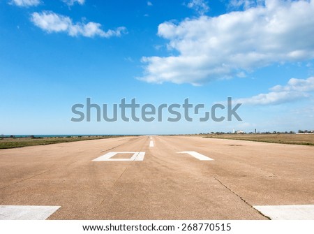 Runway, airstrip in the airport terminal with marking on blue sky with clouds background. Travel aviation concept...