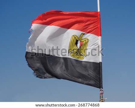 Egyptian flag flapping in the wind against blue sky