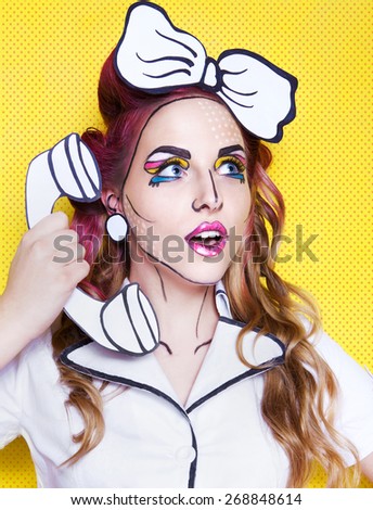 Photo of surprised young woman with a phone and professional comic pop art make up and accessories