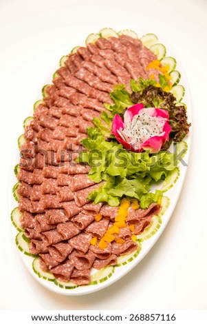 A dish of mixed cold cuts on white  