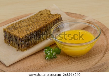 Honey with comb on the wooden background