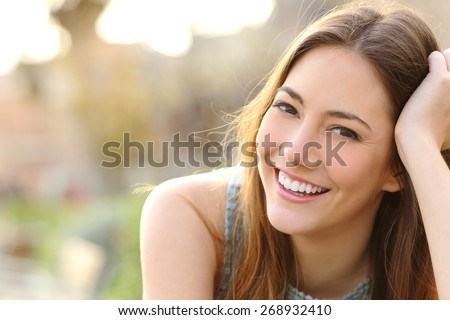 Woman smiling with perfect smile and white teeth in a park and looking at camera Royalty-Free Stock Photo #268932410