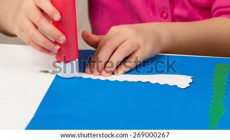 Child makes application of colored paper
