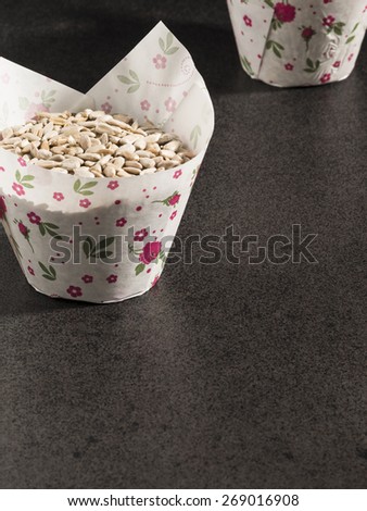 Sunflower seeds in paper form on dark background