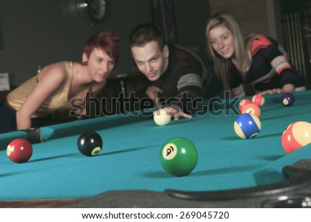 some friends play snooker in a bar.
