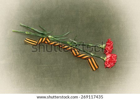 Red carnation flowers and George Ribbon on an abstract green background. May 9 Victory Day