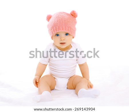 Portrait of sweet baby sitting in the pink knitted hat