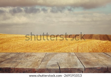 wood board table in front of field of wheat . Ready for product display montages
