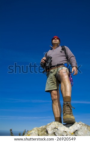 A male Mountain guide watching from above over a rock