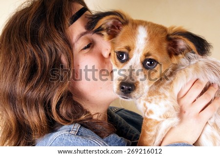 Studio shot of a young lady holding a little dog