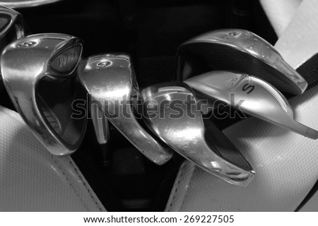 golf club, black tone color ,A brand new set of golf club irons,  clubs drivers over green field background