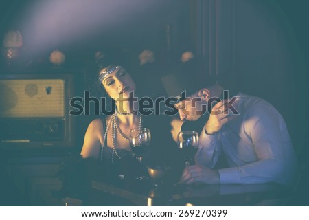 Retro couple.Couple with glasses of red wine in restaurant.Fashion,retro, vintage, tones.Retro couple.Couple with glasses of red wine in restaurant.Fashion,retro, vintage, tones. Antique picture .