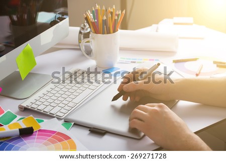 Young Handsome Graphic designer using graphics tablet to do his work at desk Royalty-Free Stock Photo #269271728