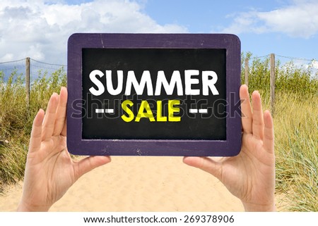 Hands holding blackboard with handwritten summer sale