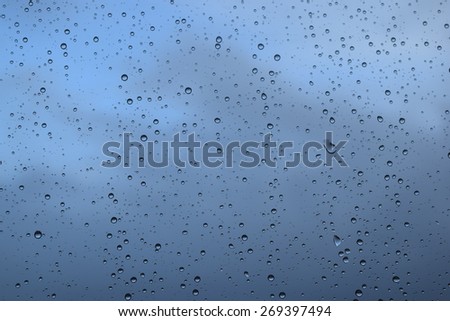 Raindrops on glass window blue