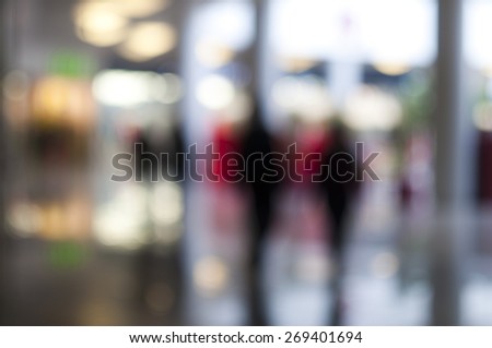 Blurred background: people walking by shopping-mall, bokeh, shop-windows Royalty-Free Stock Photo #269401694