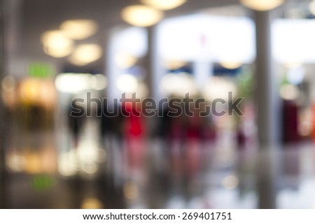 Blurred background: people walking by shopping-mall, bokeh, shop-windows Royalty-Free Stock Photo #269401751