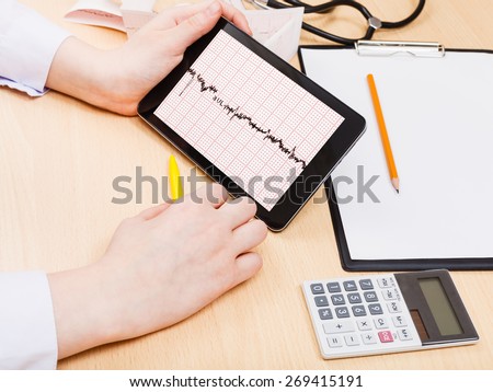 medic checks patient electrocardiogram on tablet pc
