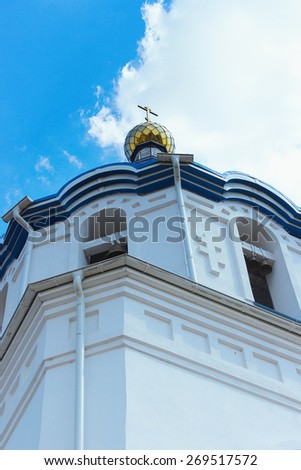A Golden dome with a cross of the Church on a cloudy sky background