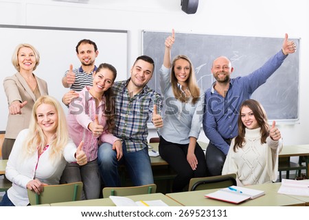 Cheerful smiling adult students and coach posing at training session school. Selective focus Royalty-Free Stock Photo #269523131