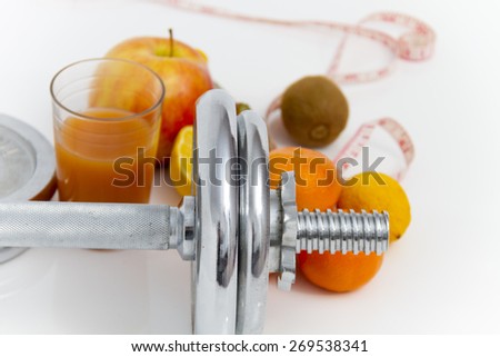 Fitness equipment and healthy food, apple, nectarines, kiwi, lemon, juice, dumbbells  and measuring tape