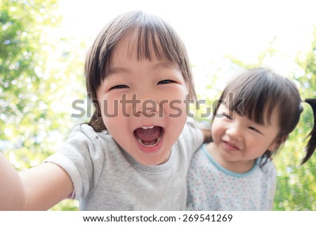 Happy child take a selfie in the park, asian