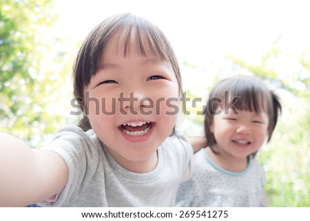 Happy child take a selfie in the park, asian