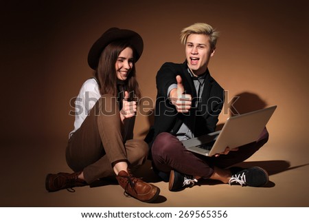 Young couple of students with laptop, teenage couple sitting at a laptop, learning, study