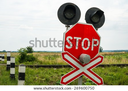 Traffic lights, stops sign and crossbuck sign at the railroad crossing in Ukraine